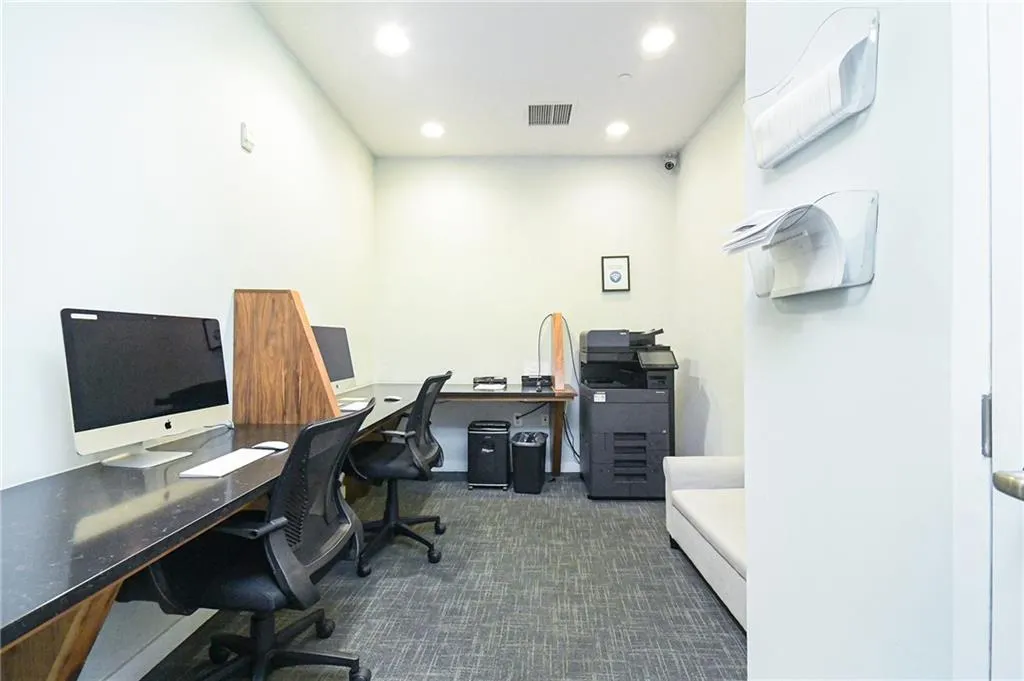 Office with dark carpet and recessed lighting