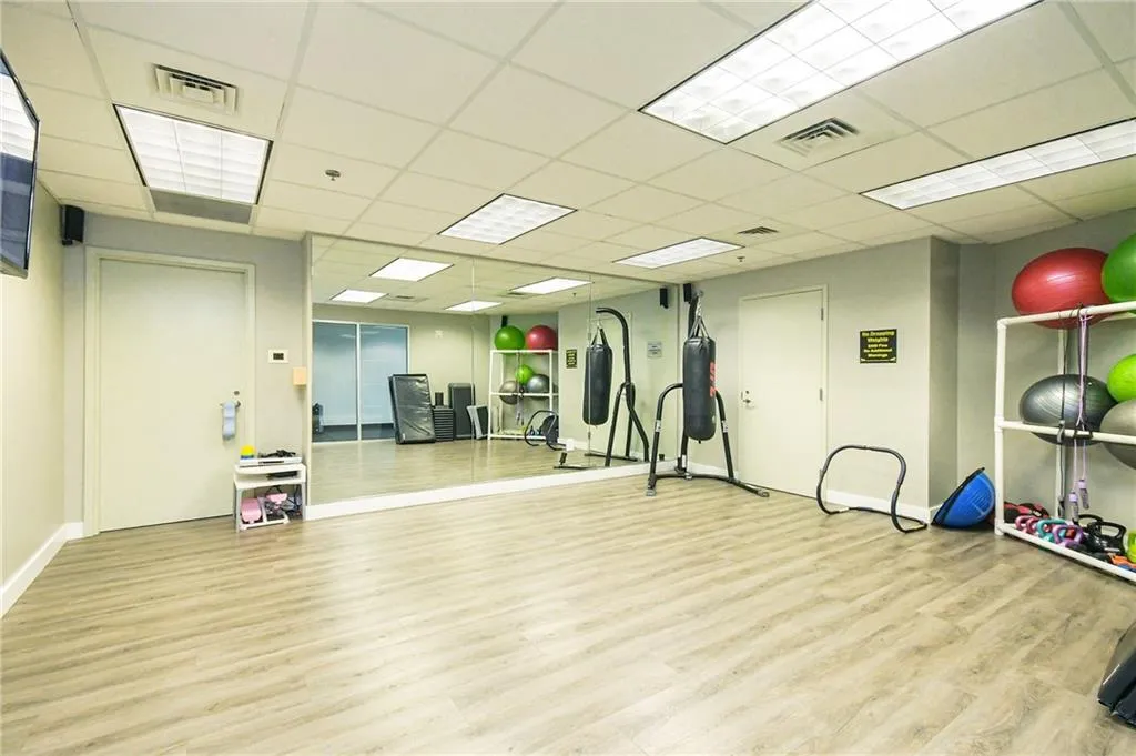 Exercise room with wood finished floors and a paneled ceiling