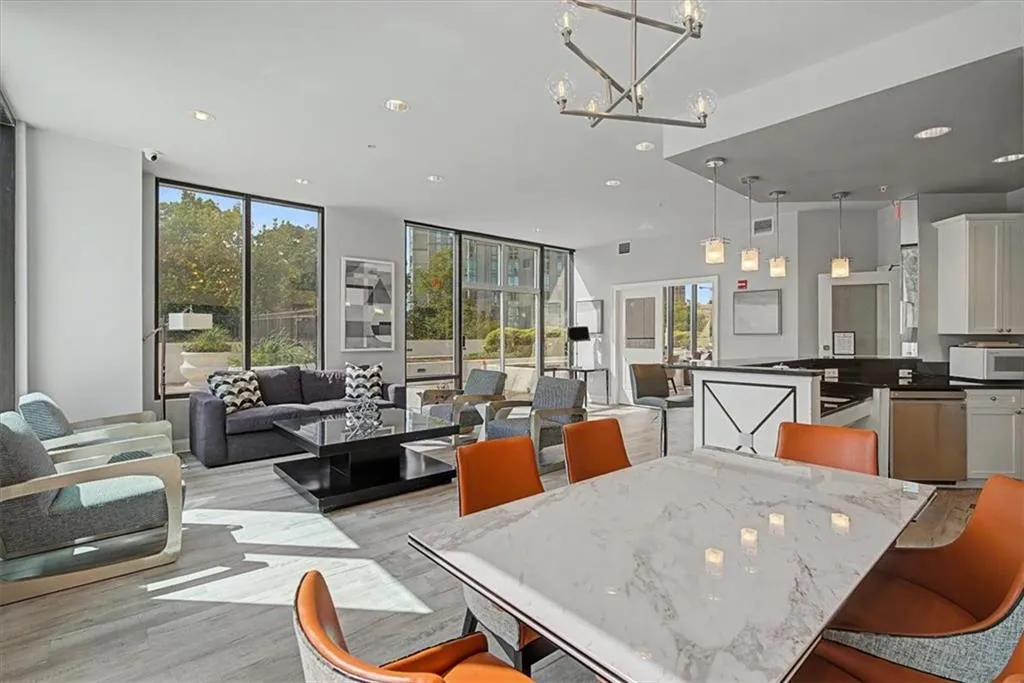 Open-concept common area featuring wood-finish flooring, a contemporary chandelier, and recessed lighting