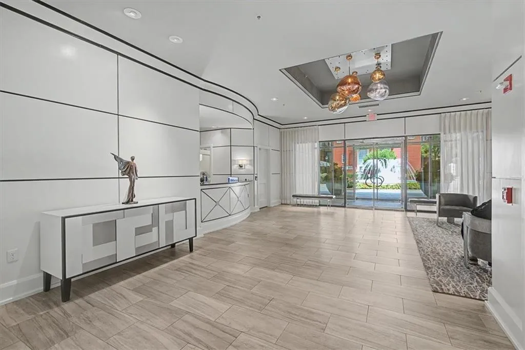 Spacious lobby featuring wood-finish flooring, recessed lighting, and a unique ceiling light fixture