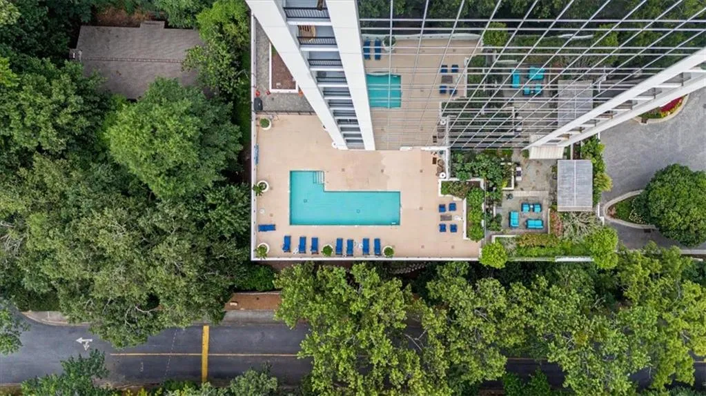 Rooftop amenity deck featuring two pools, extensive sun lounging areas, and lush landscaping