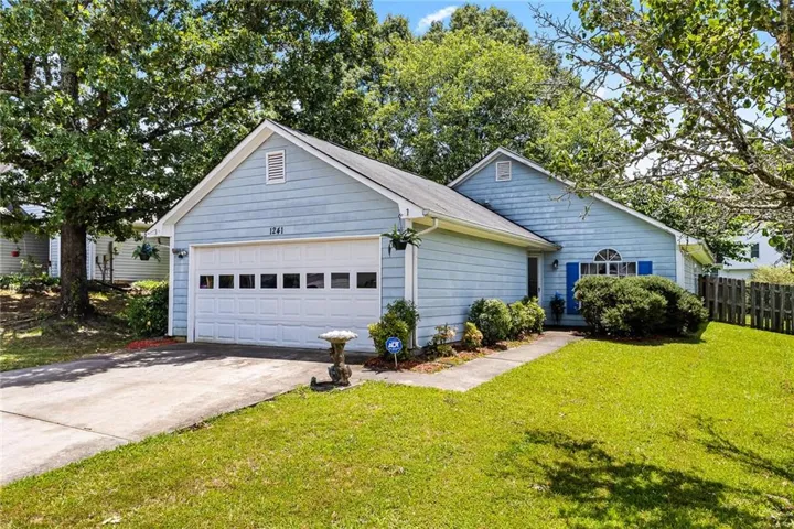 Single story home with concrete driveway and an attached garage