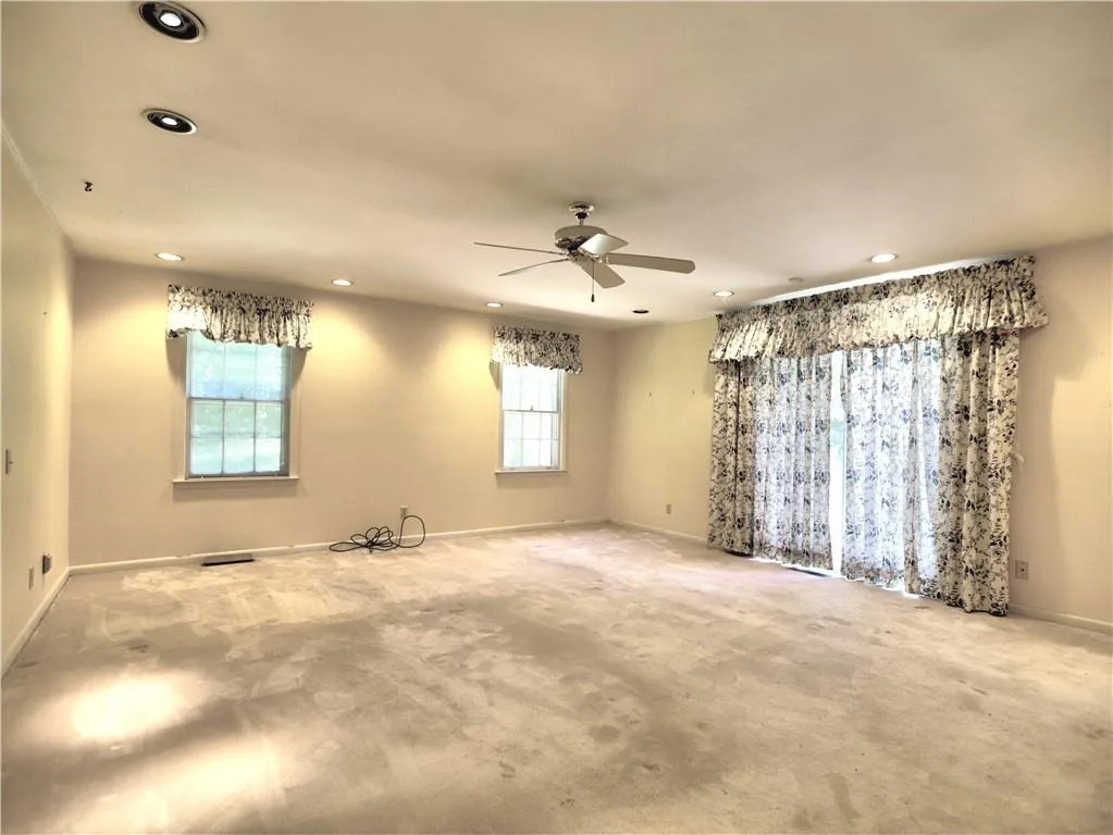 Unfurnished room with a wealth of natural light and ceiling fan