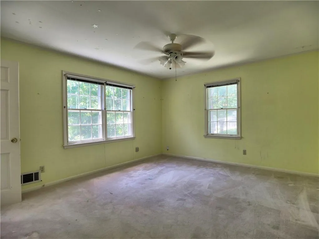 Carpeted spare room featuring ceiling fan