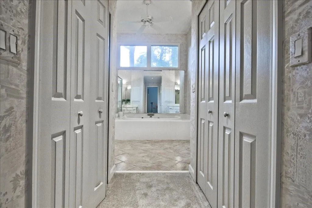 Bathroom featuring a closet, a bath, ceiling fan, and tile patterned floors