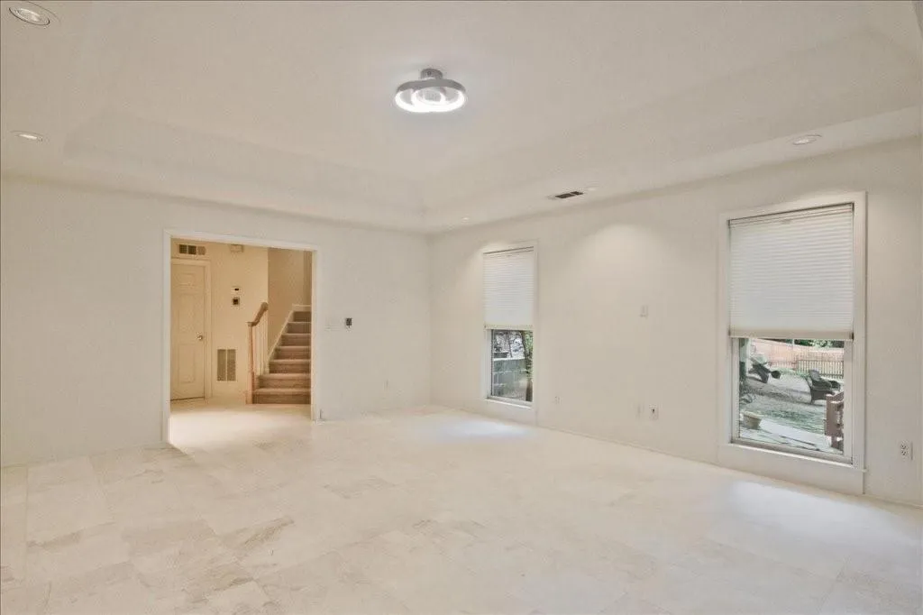 Spare room featuring recessed lighting, stairs, and a raised ceiling