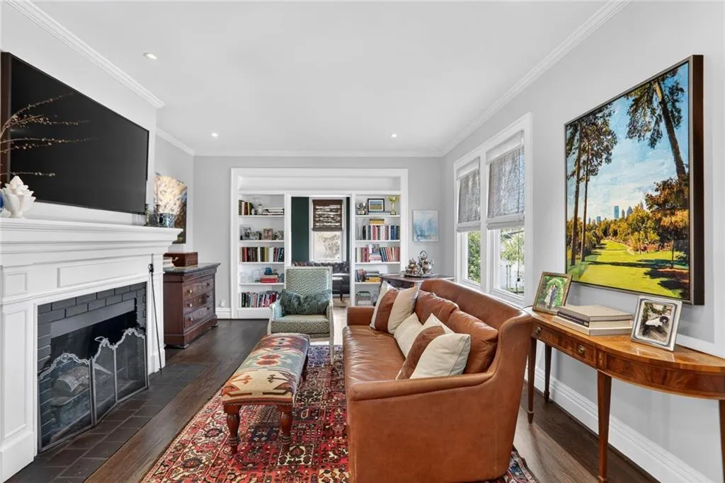 Living area with gas starter/wood burning fireplace, built-in bookcases with charming doors leading to office/den