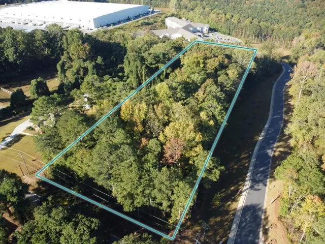 View of property location featuring a heavily wooded area and property boundaries highlighted
