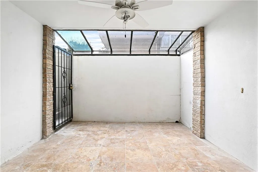 View of patio featuring a sunroom and a ceiling fan