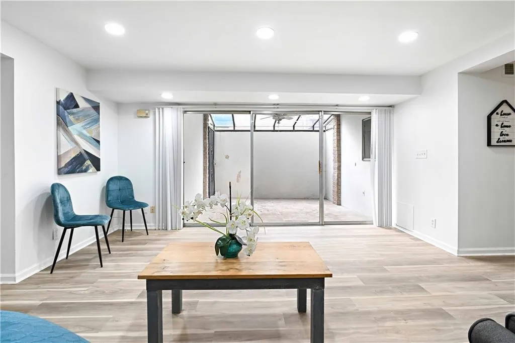 Living area with light wood finished floors and recessed lighting