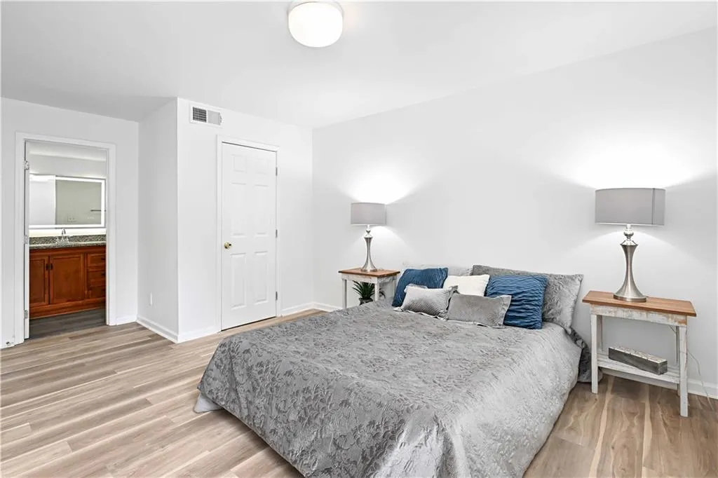 Bedroom featuring light wood-type flooring and ensuite bathroom