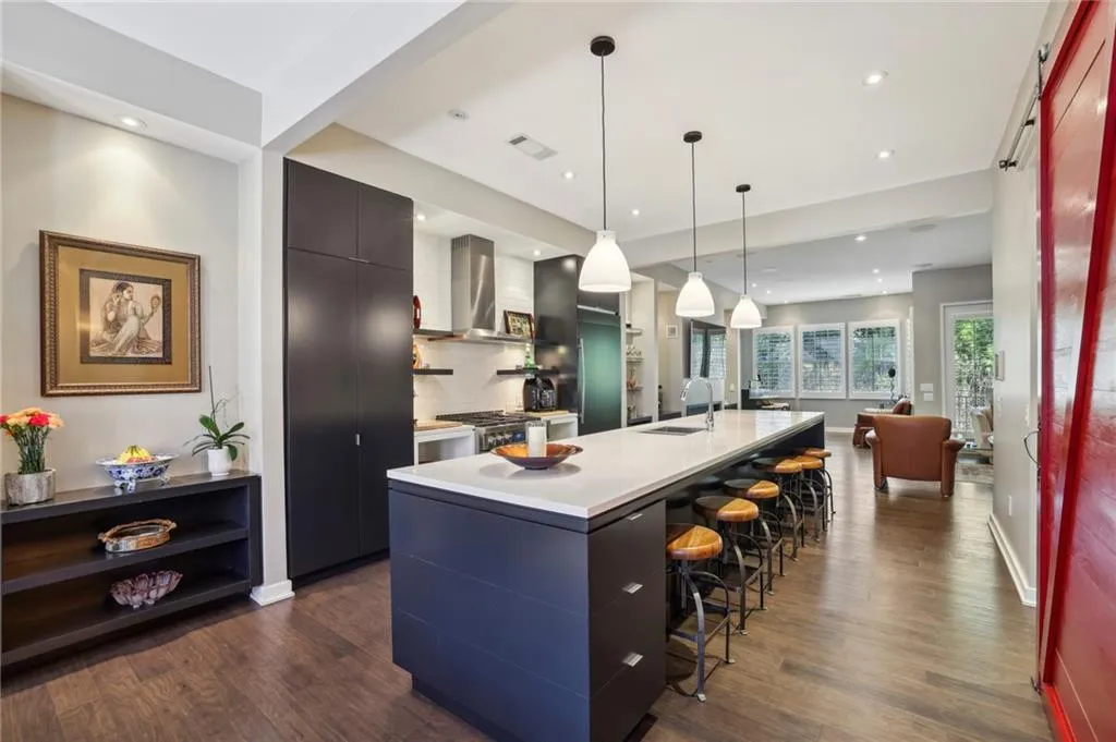 Extra wide townhome (19') provides plenty of room on all 3 finished levels. high end stainless steel appliances and paneled fridge. Breakfast bar can comfortably seat 6. View towards kitchen with family living in the background.