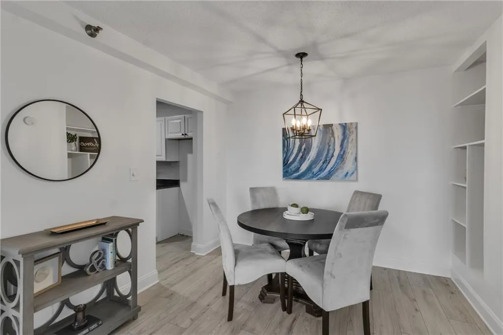 Dining space with a chandelier, light wood finished floors, and a textured ceiling