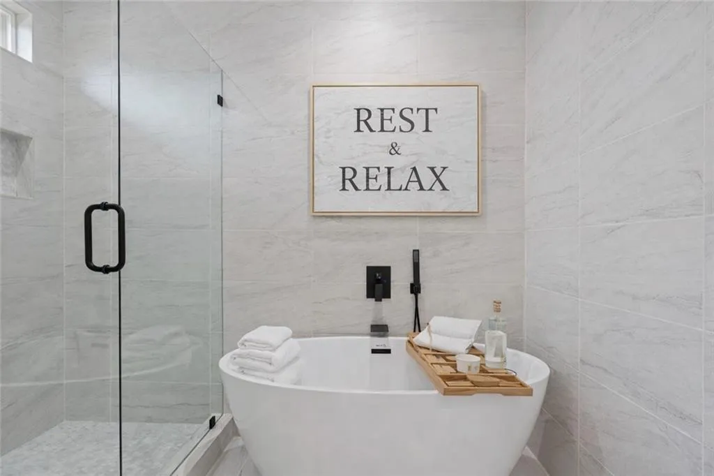 Virtually stagedJunior suiteBathroom featuring a Soaking tub, tile walls, and a shower stall