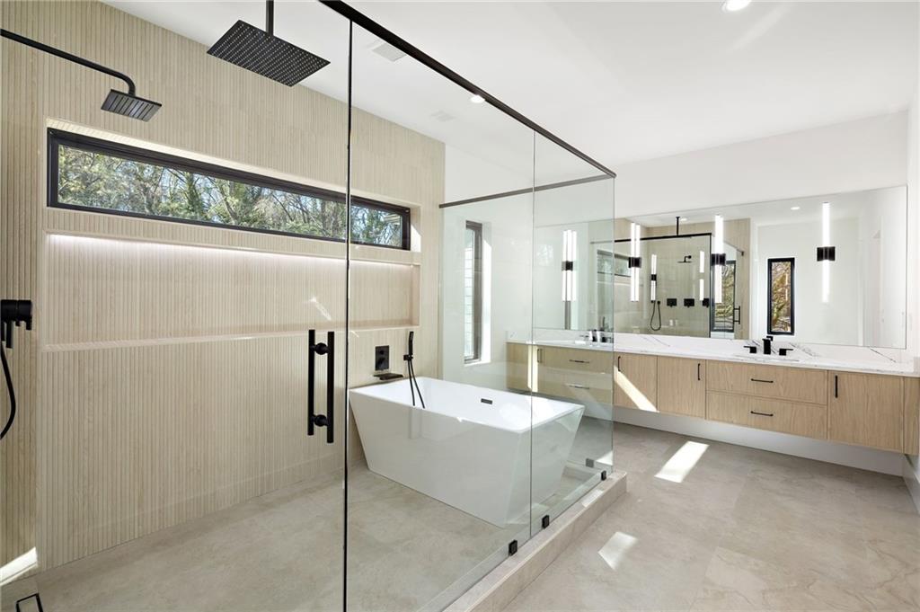 The spa-grade bathroom features featuring high-end fixtures, a spacious walk-in shower, a luxurious soaking tub, and designer finishes that create a serene atmosphere.