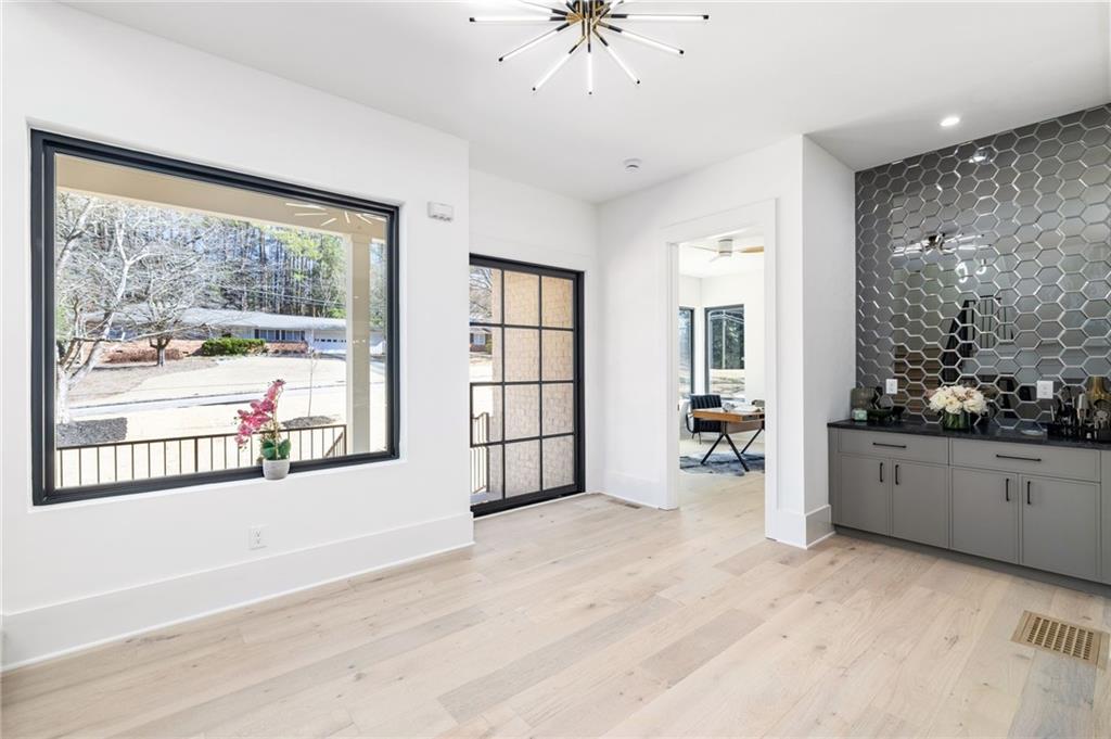 Doorway with light hardwood / wood-style floors and a notable chandelier