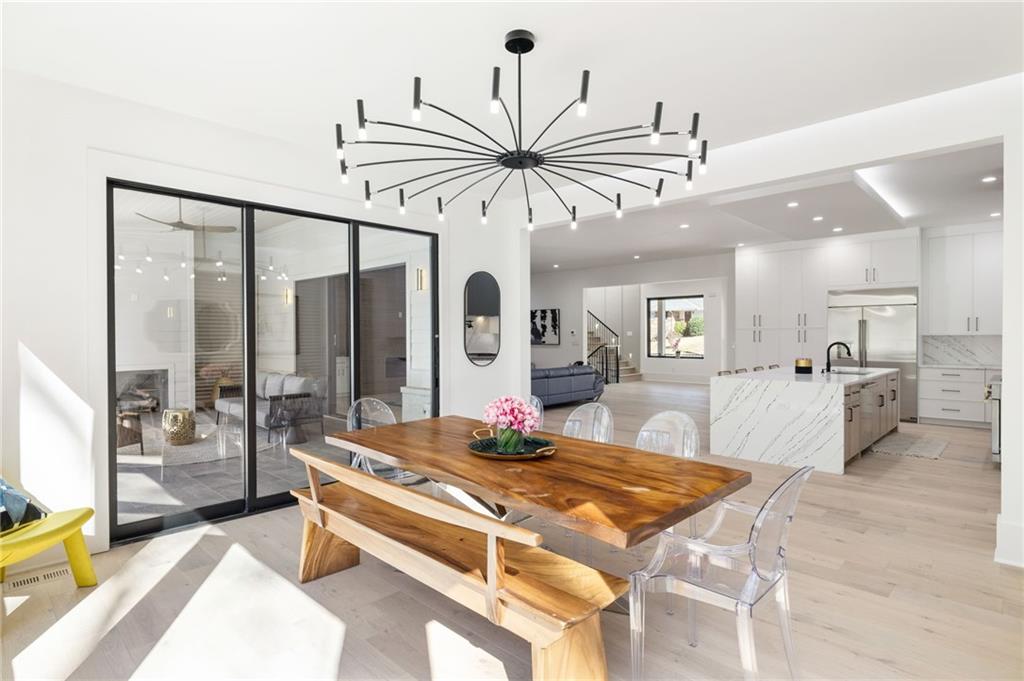 The chef’s kitchen is a culinary delight, equipped with top-of-the-line stainless steel appliances, custom cabinets, quartz countertops, a spacious island, a meticulously designed walk-in pantry, and an open dining room perfect for entertaining.