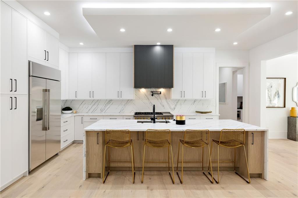 The chef’s kitchen is a culinary delight, equipped with top-of-the-line stainless steel appliances, custom cabinets, quartz countertops, a spacious island, a meticulously designed walk-in pantry, and an open dining room perfect for entertaining.