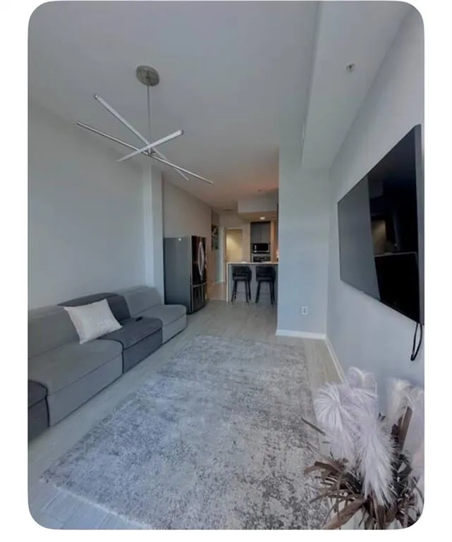 Living area featuring a chandelier and baseboards