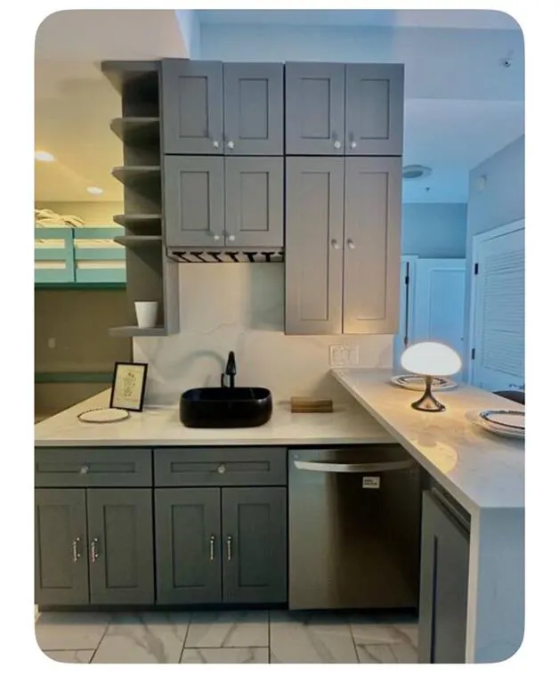 Kitchen featuring arched walkways, stainless steel dishwasher, open shelves, a peninsula, and recessed lighting