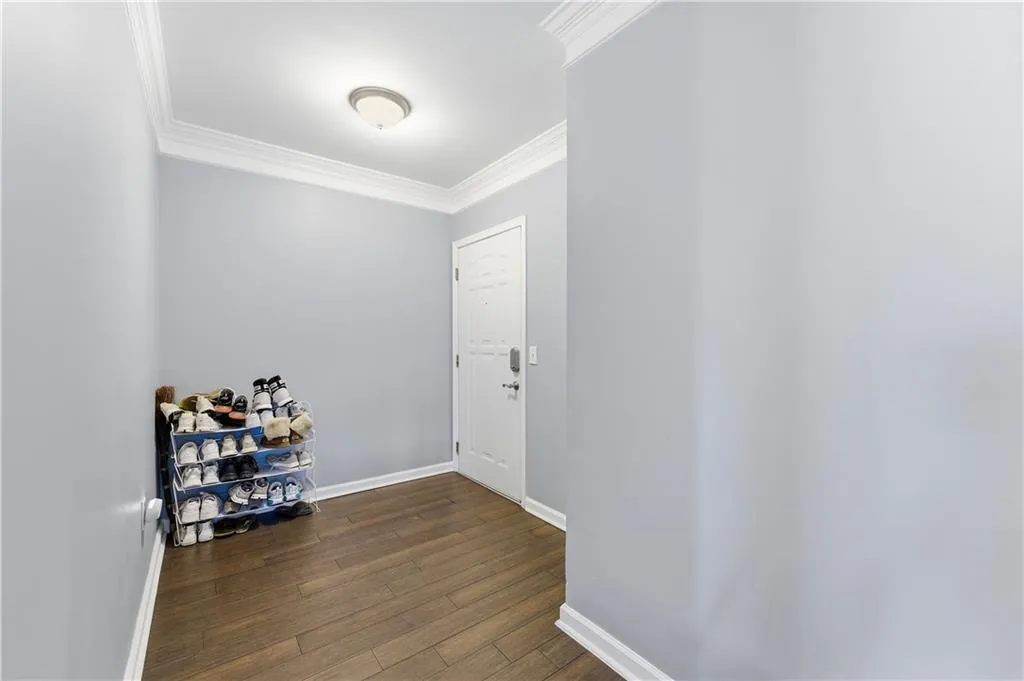 Foyer with crown molding and dark wood-type flooring