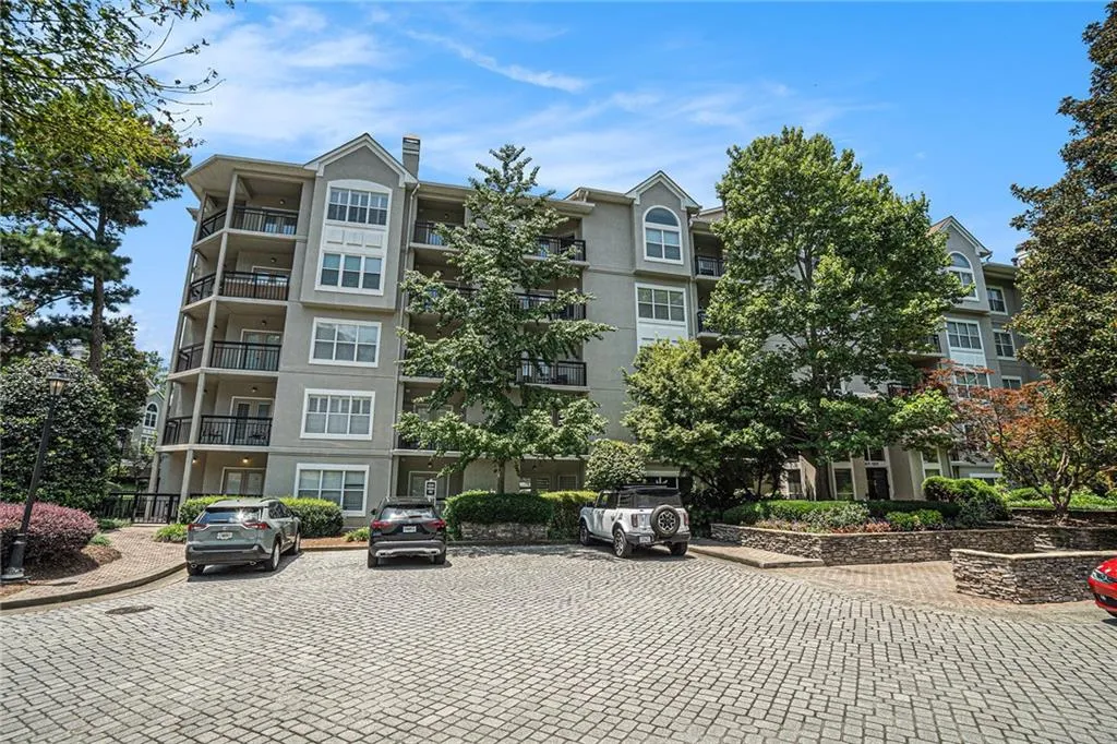 View of apartment building / complex with uncovered parking
