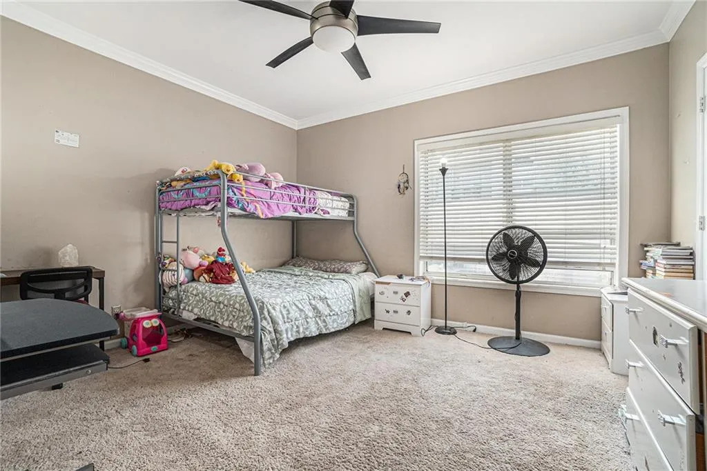 Bedroom featuring carpet, crown molding, and ceiling fan