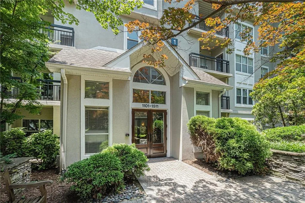 Entrance to property featuring stucco siding, french doors, and roof with shingles