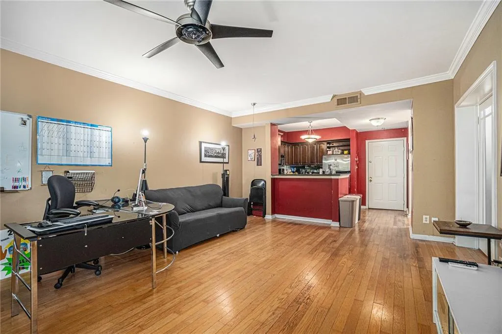 Office featuring ceiling fan, light wood finished floors, and ornamental molding