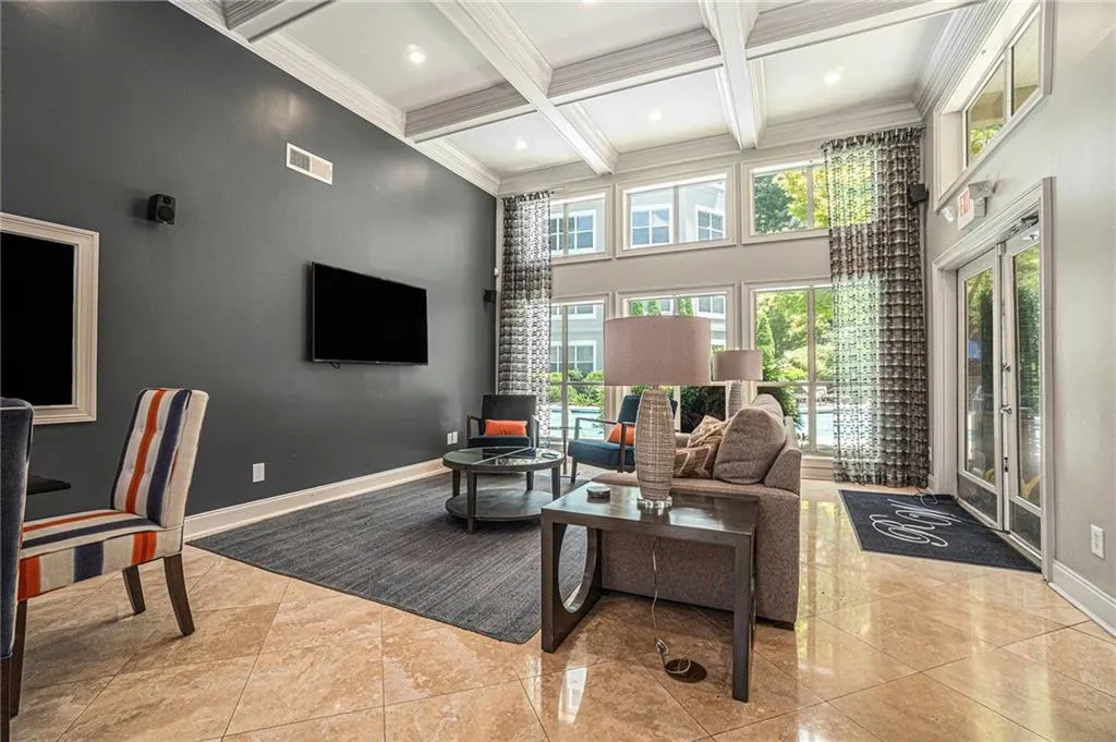 Tiled living room with a towering ceiling, coffered ceiling, beam ceiling, and ornamental molding