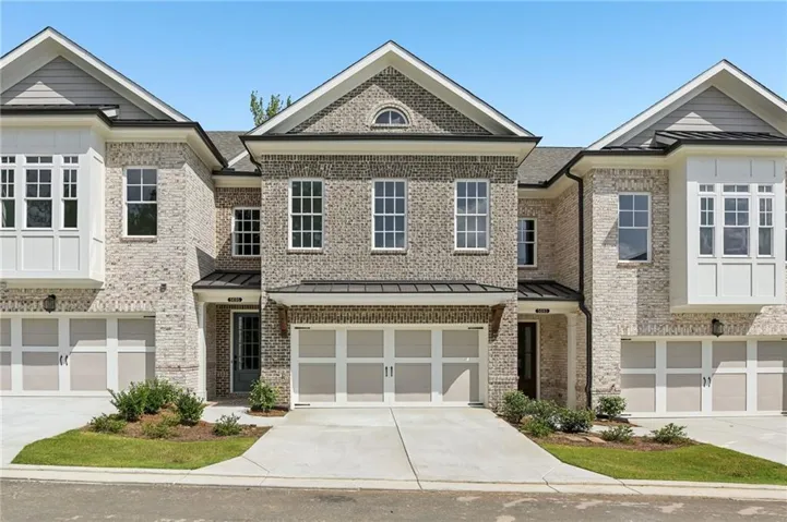 Brick exterior with gabled roofs, bay windows, attached two-car garage, and concrete driveways
