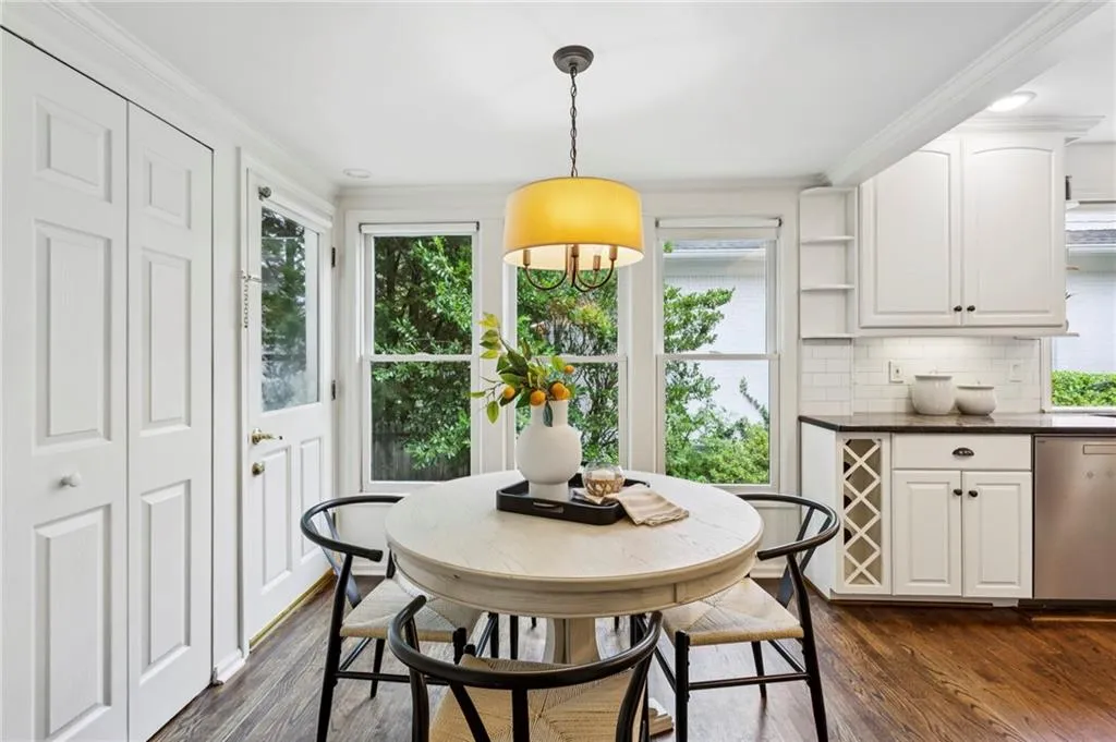 Dining area with healthy amount of natural light, dark wood finished floors, and crown molding