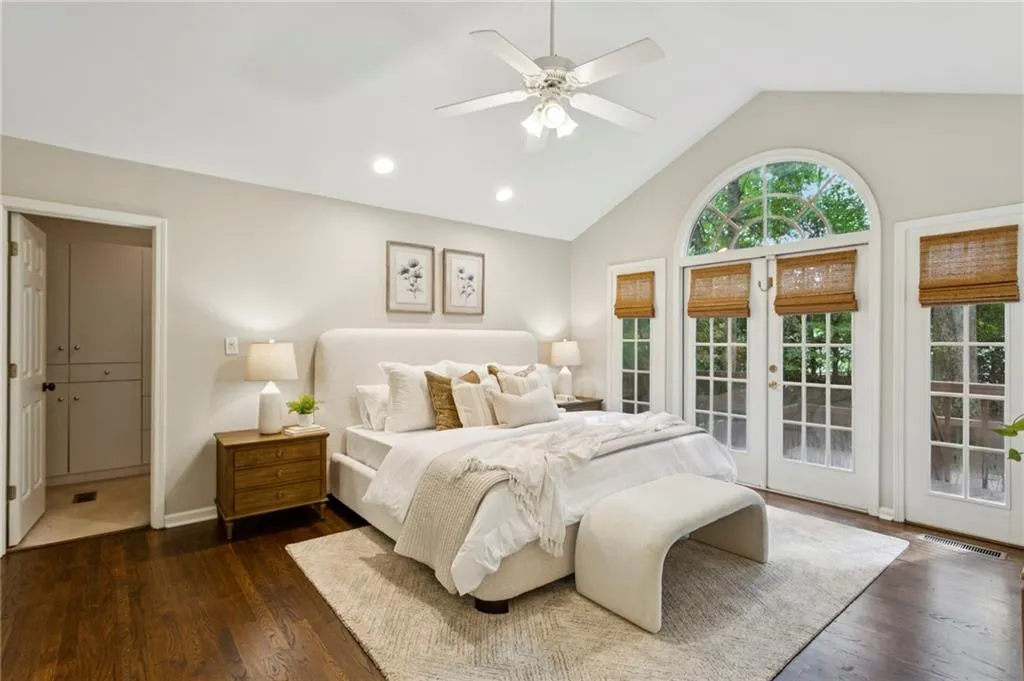 Bedroom with access to outside, recessed lighting, dark wood-style flooring, french doors, and high vaulted ceiling