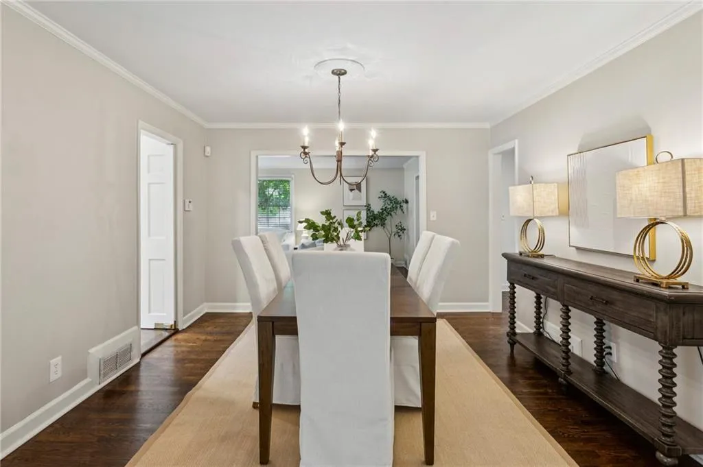 Dining area featuring ornamental molding, dark wood-type flooring, and a chandelier