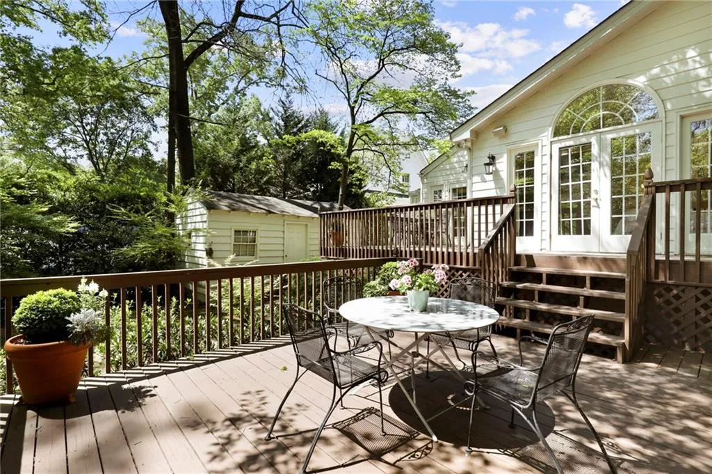 Wooden terrace with a storage shed and outdoor dining space