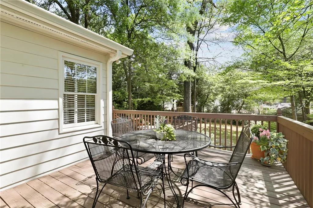 Wooden deck featuring outdoor dining area and view of wooded area