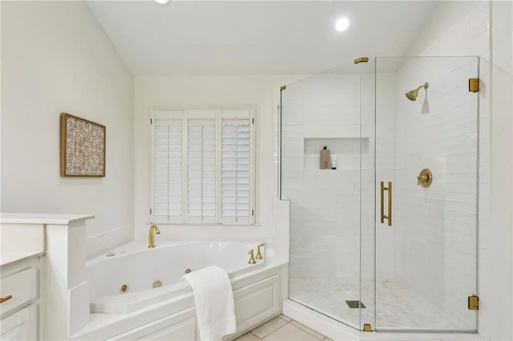 Full bathroom featuring a whirlpool tub, vanity, a stall shower, light tile patterned flooring, and recessed lighting