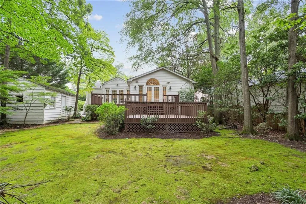 Back of house featuring a wooden deck and a yard
