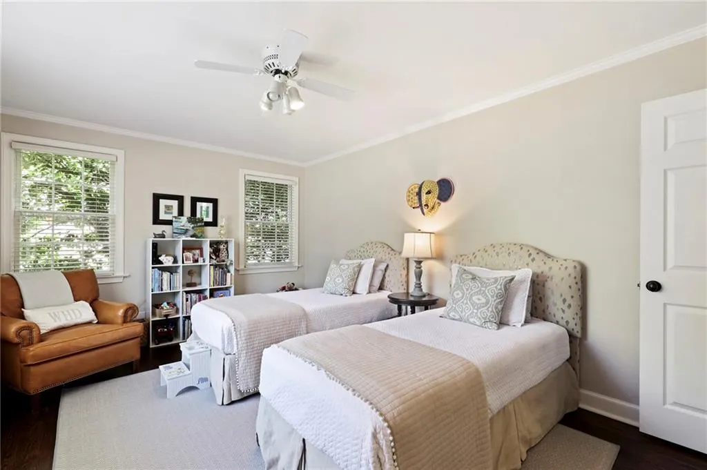 Bedroom with ornamental molding, dark wood-style flooring, and a ceiling fan