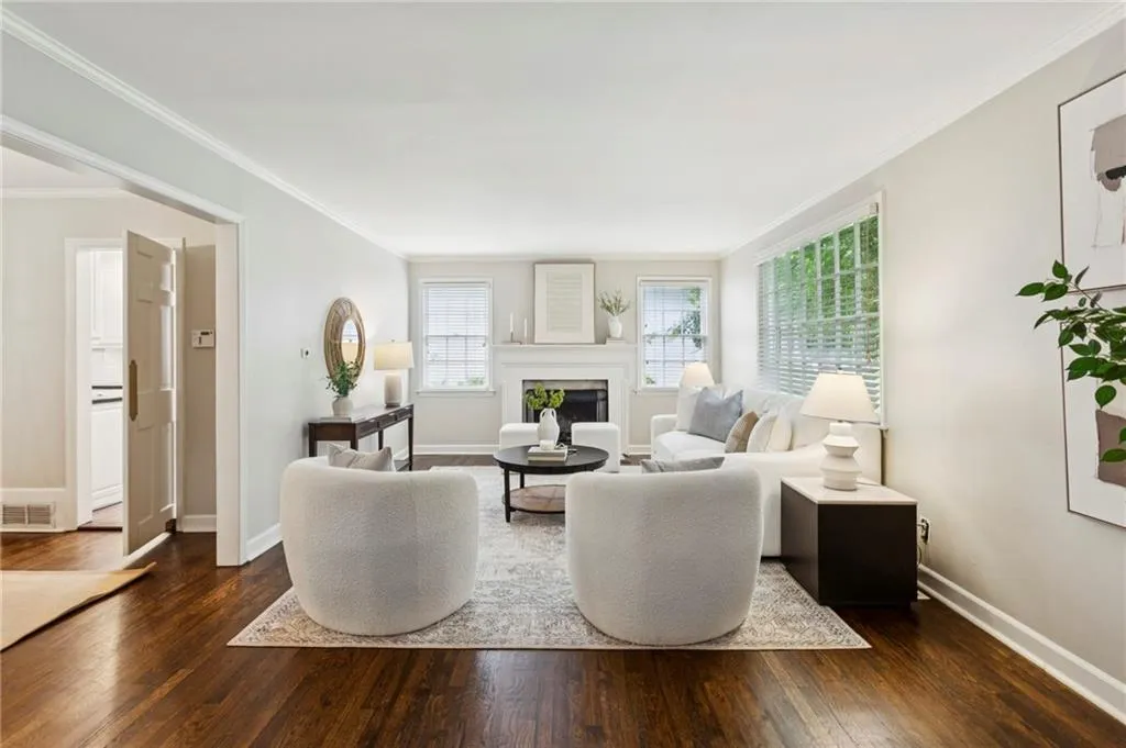 Living area featuring crown molding, a fireplace, and dark wood finished floors
