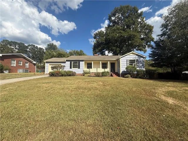 Single-story residence featuring light blue siding, a covered front porch, and an attached garage