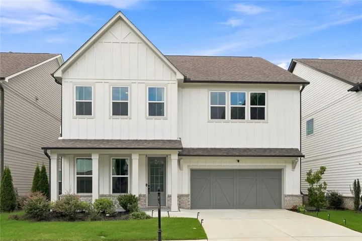 Contemporary two-story residence featuring a white board and batten facade with a prominent front gable