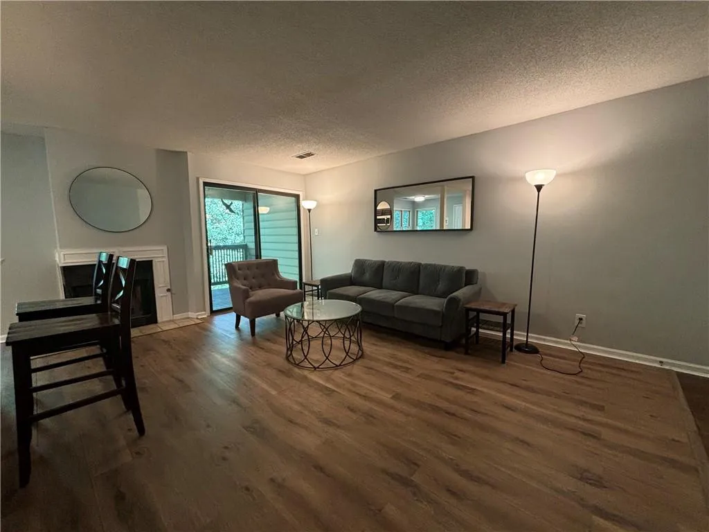 Living room with a textured ceiling and dark wood-type flooring