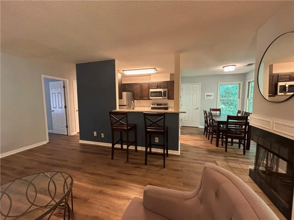 Living room with a textured ceiling and wood-type flooring