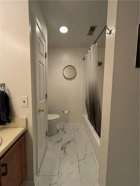 Full bathroom featuring tile patterned flooring, vanity, shower / tub combo with curtain, and toilet