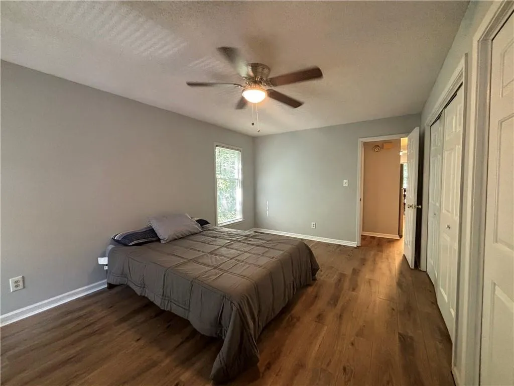 Bedroom featuring ceiling fan, a textured ceiling, and dark hardwood / wood-style flooring