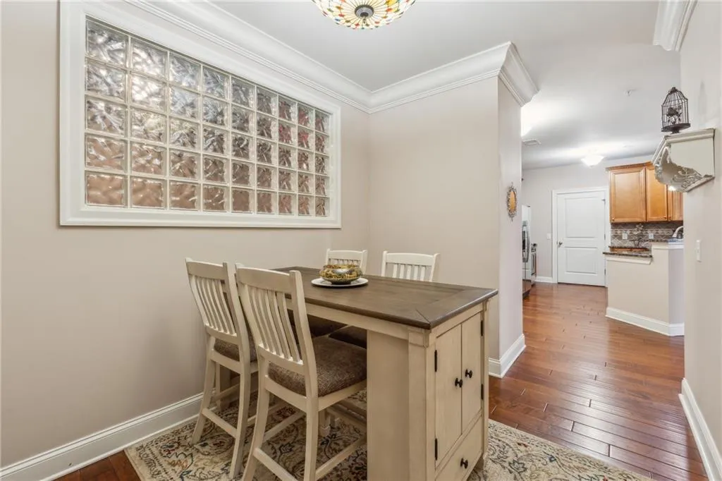 Dining space with hardwood / wood-style floors and crown molding