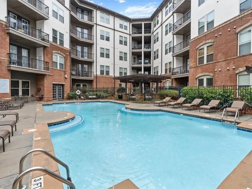 View of swimming pool featuring pool water feature and a pergola