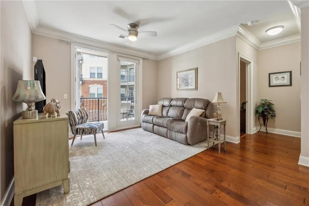 Living room with hardwood / wood-style floors, ceiling fan, and crown molding