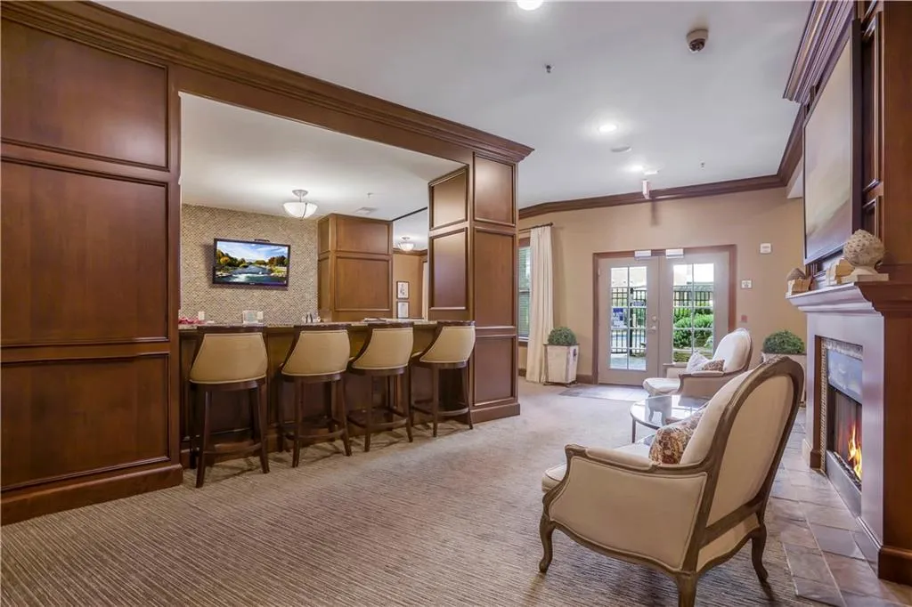 Sitting room with light colored carpet, ornamental molding, and french doors